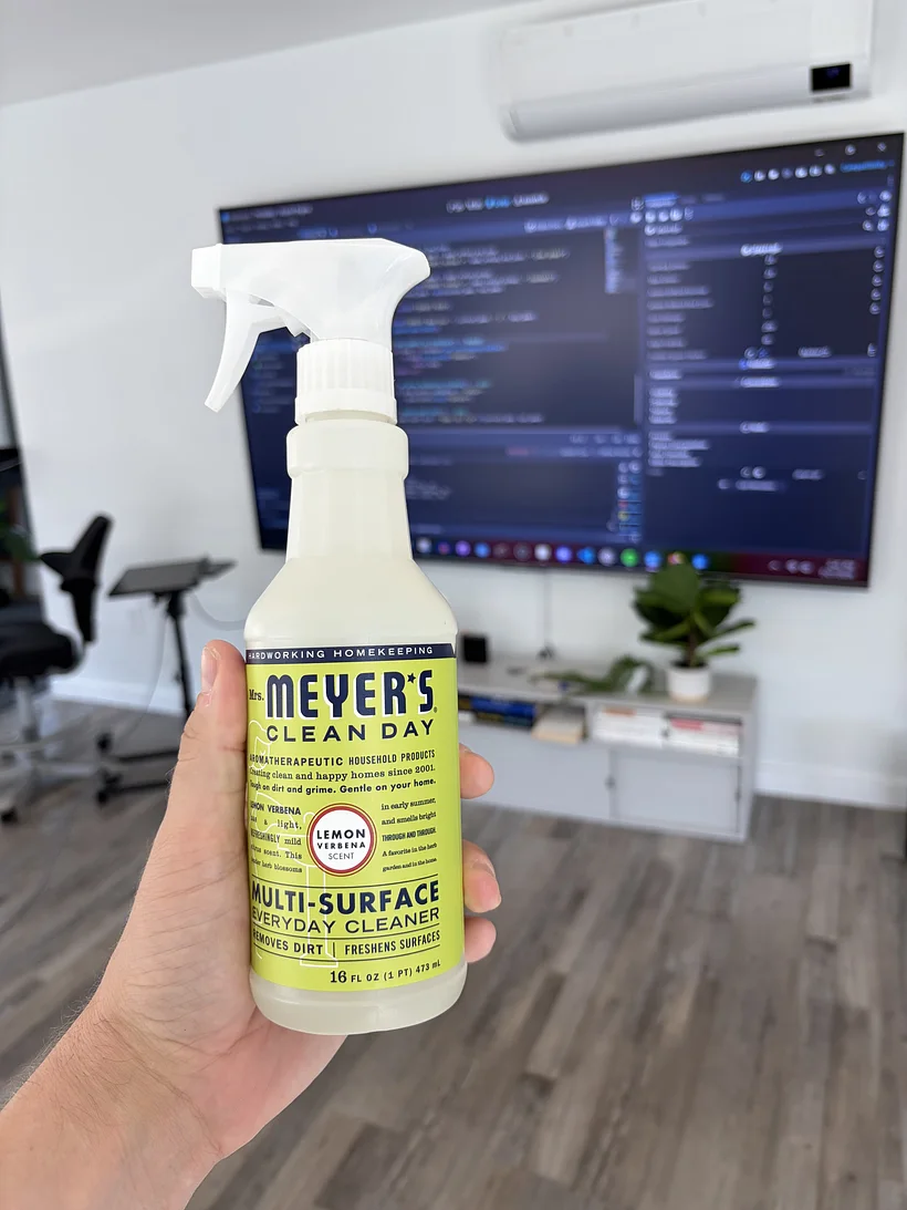 A bottle of Mrs. Meyer’s cleaner held in front of the Godot game editor